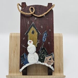 Birdhouses against a snowy backdrop/sled and snowman